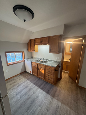 Wausau apartment for rent - A kitchen with wooden cabinets and a window.