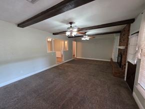 Harrah house for rent - A room with a ceiling fan and carpeted floor.