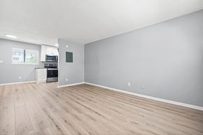 Atlanta apartment for rent - A spacious room with wooden flooring and a kitchenette in the corner.