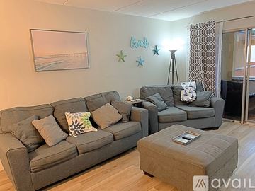 Mary Esther apartment for rent - A living room with a grey couch and a grey ottoman.