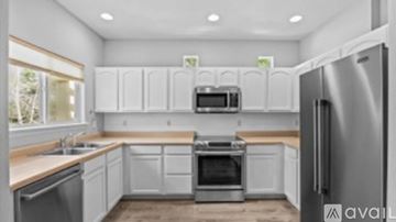 Grand Junction house for rent - A modern kitchen with white cabinets and stainless steel appliances.