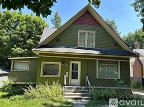 Spokane townhouse for rent - A green house with a red roof and a white door.