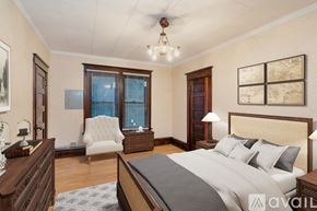 Spokane townhouse for rent - A bedroom with a large bed, a chair, and a ceiling fan.