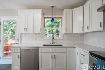 Durham house for rent - A kitchen with white cabinets and a stainless steel dishwasher.