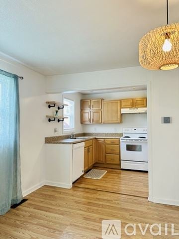 Huntington house for rent - A kitchen with wooden cabinets and a white stove top oven.
