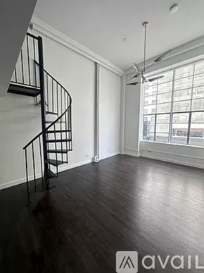 New York apartment for rent - A room with a spiral staircase and a window.