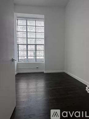 New York apartment for rent - A room with a window and wooden flooring.