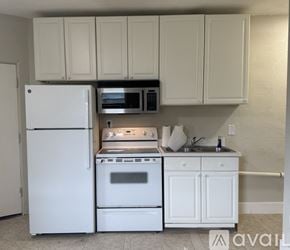 Orlando house for rent - A white refrigerator and oven in a kitchen with white cabinets.