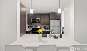 New York apartment for rent - A modern kitchen with a white table and chairs, a sink, a refrigerator, a microwave, and a stove.