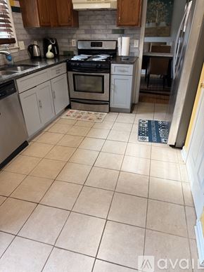 Lawrenceville house for rent - A kitchen with a tile floor and a refrigerator.