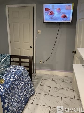 Lawrenceville house for rent - A bedroom with a bed and a television displaying a food program.