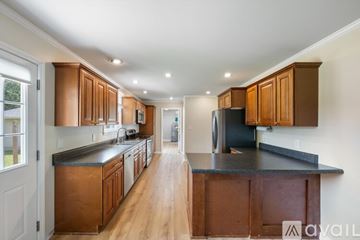 Franklin house for rent - A kitchen with wooden cabinets and a black countertop.