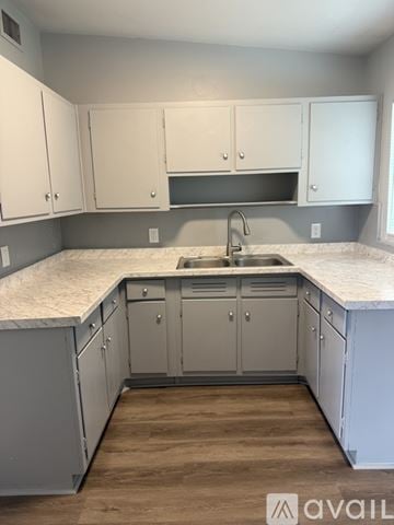 Sanford house for rent - A kitchen with white cabinets and a marble countertop.