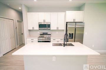 Kissimmee house for rent - A kitchen with white cabinets and appliances is available for rent.