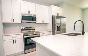 Kissimmee house for rent - A kitchen with white cabinets and appliances.