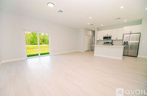 Kissimmee house for rent - A spacious, empty room with white walls and wooden flooring.
