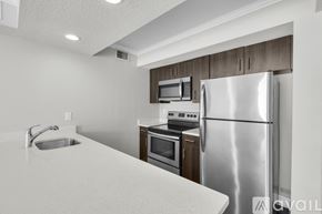 Kissimmee apartment for rent - A kitchen with a stainless steel refrigerator, microwave, oven, and sink.