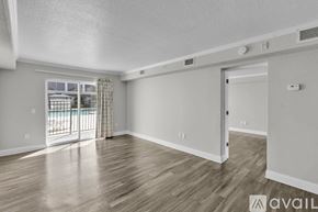 Kissimmee apartment for rent - A spacious room with wooden flooring and a sliding glass door leading to a balcony.