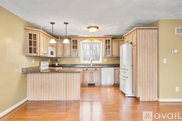 Pelham house for rent - A kitchen with wooden cabinets and a granite countertop.