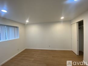 Seattle house for rent - A house with a grey roof and a small porch surrounded by trees.