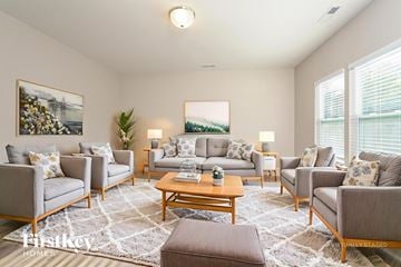 High Point house for rent - A living room with a grey couch, a wooden coffee table, and a painting on the wall.
