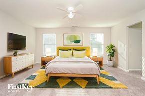 High Point house for rent - A bedroom with a bed, dresser, and ceiling fan.