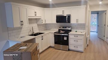 Bridgewater apartment for rent - A kitchen with white cabinets and a black microwave above the stove.