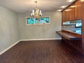 Statesboro house for rent - A room with a wooden floor and a chandelier hanging from the ceiling.
