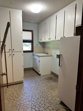 Statesboro house for rent - A kitchen with white cabinets and a white refrigerator.