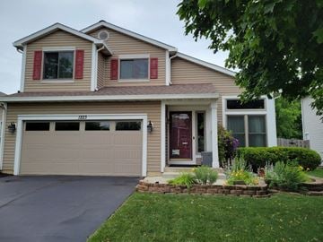 Waukegan house for rent - A house with a brown garage door and a red door.