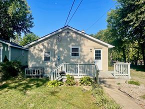 New Albany house for rent - A house with a green lawn and trees in the background.