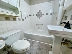 New Albany house for rent - A white toilet sits next to a white sink in a bathroom.