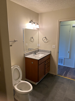 Albuquerque apartment for rent - A bathroom with a toilet, sink, and mirror.