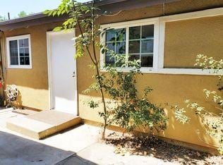 Los Angeles house for rent - A small house with a white door and a tree in front.