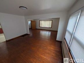 Belleville apartment for rent - A room with wooden flooring and a window with blinds.