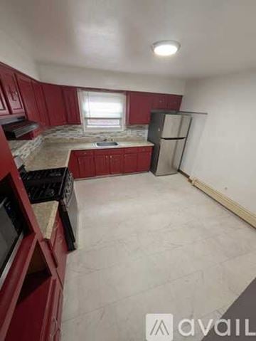 Belleville apartment for rent - A kitchen with red cabinets and a black stove top oven.