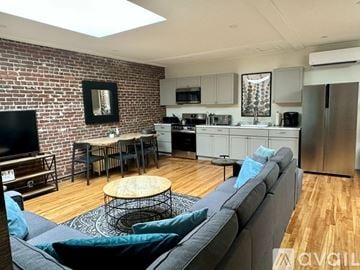 Ellsworth apartment for rent - A living room with a grey couch and a brick wall.