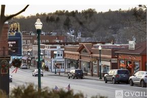 Ellsworth apartment for rent - A street view of a small town with cars driving on the road and buildings on the side.