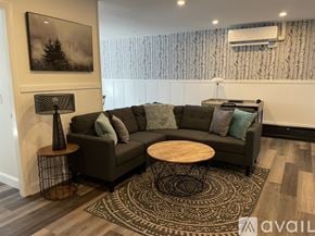 Ellsworth apartment for rent - A living room with a grey couch, a wooden table, and a patterned rug.