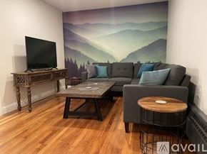 Ellsworth apartment for rent - A living room with a grey couch, a wooden coffee table, and a television.