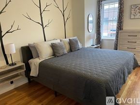 Ellsworth apartment for rent - A bedroom with a large bed and a tree mural on the wall.