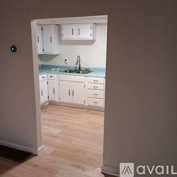Claysburg apartment for rent - A kitchen with white cabinets and drawers is visible from an open door.