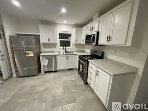 Harford house for rent - A kitchen with white cabinets and a grey floor.