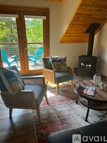 Whitefish apartment for rent - A living room with a wood stove and a table with a vase on it.