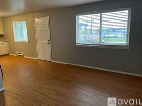 Sea Tac apartment for rent - A room with wooden flooring and a window with blinds.