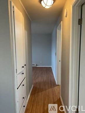 Sea Tac apartment for rent - A hallway with a wooden floor and white walls.