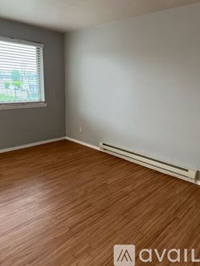 Sea Tac apartment for rent - A room with wooden flooring and a window with blinds.