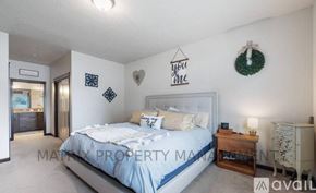 Hayden house for rent - A bedroom with a bed, nightstand, and a wreath on the wall.