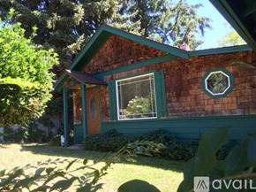 Gold Hill house for rent - A house with a green door and window is surrounded by trees.