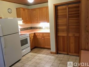 Gold Hill house for rent - A kitchen with wooden cabinets and a white refrigerator.